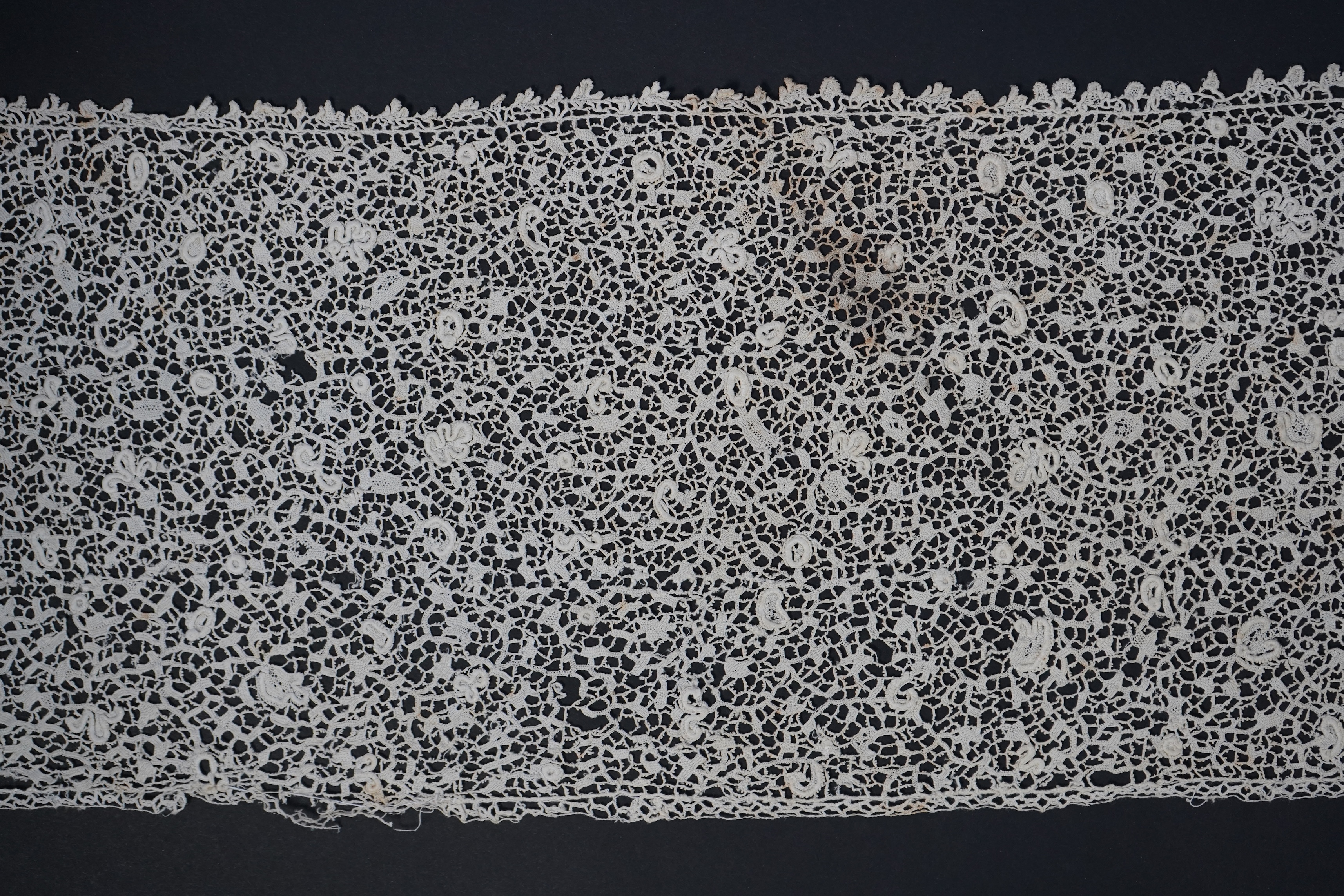 A late 17th century wide flounce of Point de France needle lace, together with a narrower flounce, both with raised elements of the design in the style of Point de Rose, but less so. This lace was very popular with the F